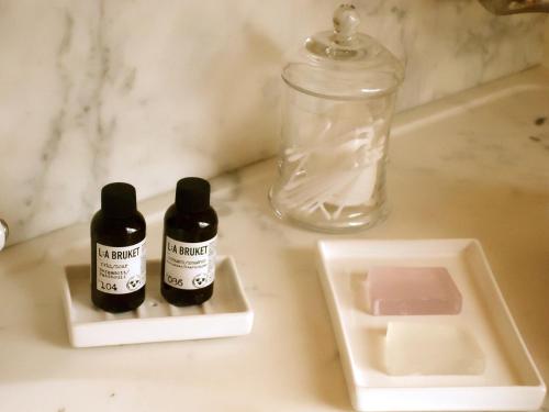 two bottles of medicine sitting on a bathroom counter at Maison Flagey Brussels in Brussels