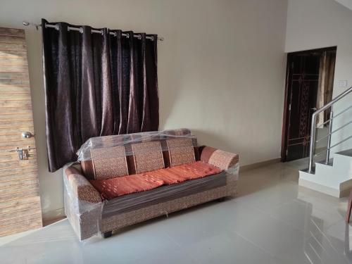 a couch sitting in a room with a window at My Nest - Best Homestay for Peaceful Stay with Comfort in Bhuj