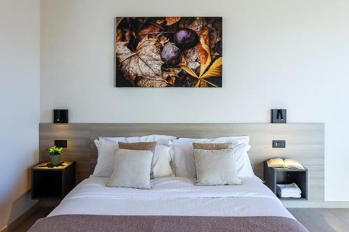 a bedroom with a large white bed with pillows at Chiabot Langhe in Roddino