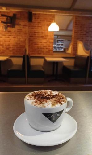 a cup of coffee sitting on a plate on a table at Hotel De La Mer in Saint Malo