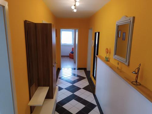 a hallway with yellow walls and a checkered floor at Lillie 3-4 Personen - Ferienwohnungen Wagner & Gaul Falkenauel in Falkenauel