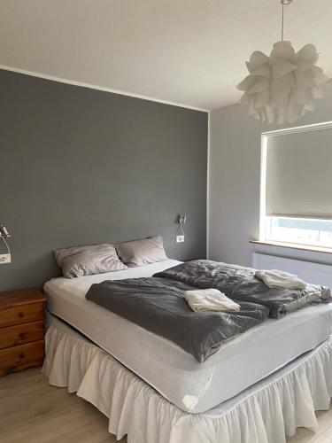 ein großes Bett in einem Schlafzimmer mit Fenster in der Unterkunft Cozy apartment in Akureyri in Akureyri