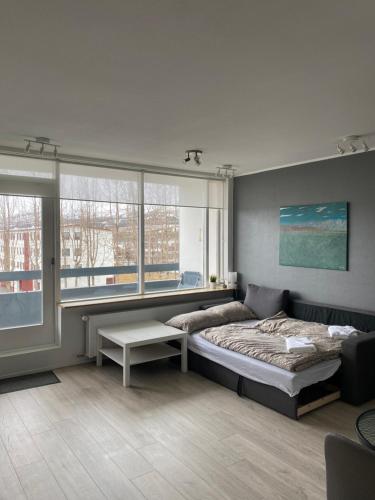 a bedroom with a bed and a large window at Cozy apartment in Akureyri in Akureyri