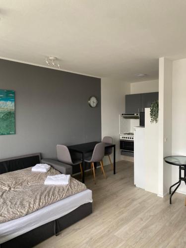 a bedroom with a bed and a table and a kitchen at Cozy apartment in Akureyri in Akureyri