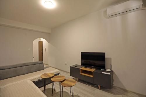a living room with a couch and a tv and stools at Hostel 42 in Skopje