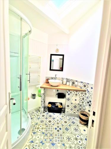 une salle de bain avec un lavabo et une douche dans l'établissement les volets bleus de Joséphine, à Binic