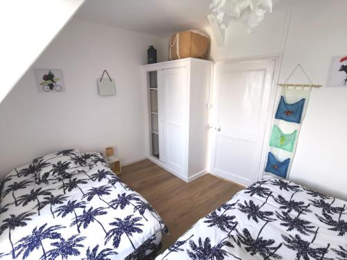 une chambre avec deux lits dans une pièce dans l'établissement les volets bleus de Joséphine, à Binic