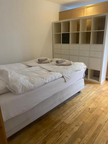 Lägenhet i Limhamn/sibbarp في مالمو: غرفة نوم بسرير كبير مع أرضية خشبية