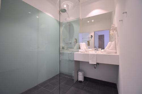 a bathroom with two sinks and a glass shower at Sporthotel Zederhaus in Zederhaus