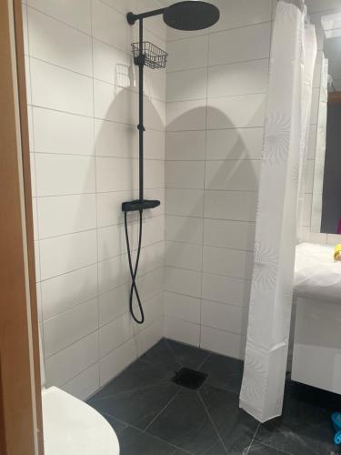 y baño con ducha con manguera negra. en Lägenhet i Limhamn/sibbarp, en Malmö