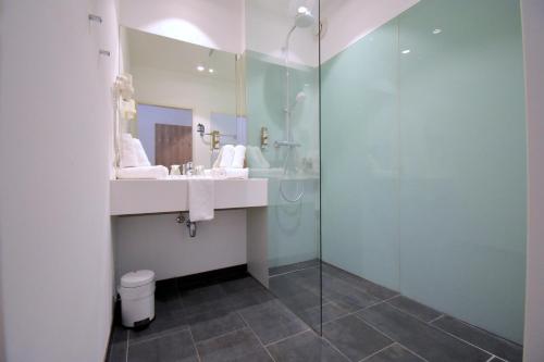 a bathroom with a sink and a glass shower at Sporthotel Zederhaus im Lungau in Zederhaus