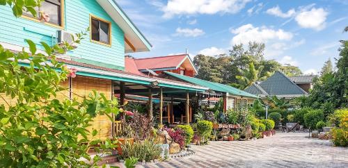 a building with a lot of plants in front of it at Bwaver Cottage in La Digue