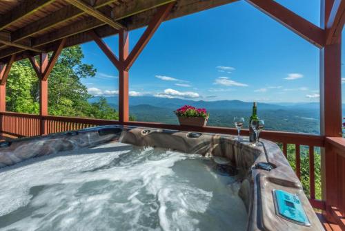 a hot tub on the deck of a cabin at Above the Clouds Log Cabin, Hot Tub & Views! in Old Fort