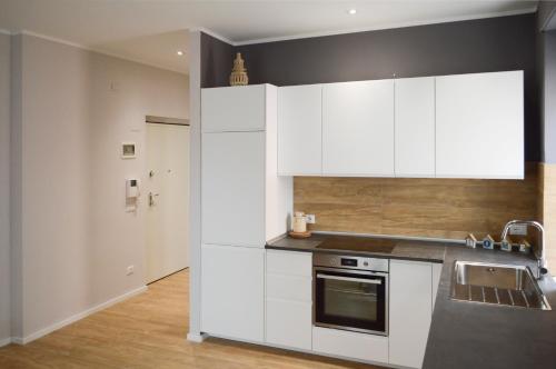 uma cozinha com armários brancos e um lavatório em Regina Apartment em Pescara