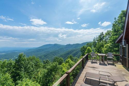 a balcony with a table and chairs and mountains at Above the Clouds Log Cabin, Hot Tub & Views! in Old Fort