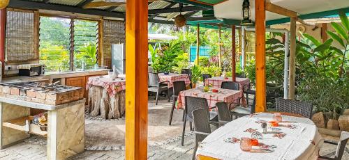 a restaurant with tables and chairs in a patio at Bwaver Cottage in La Digue