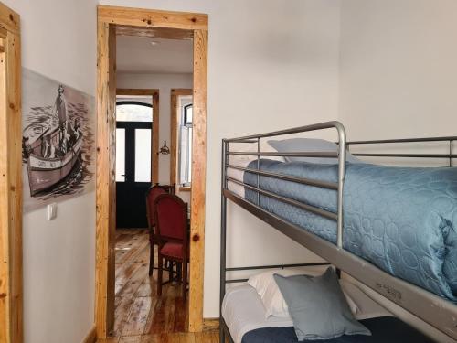 a bedroom with a bunk bed and a room with a chair at CASA SAO DOMINGOS in Setúbal