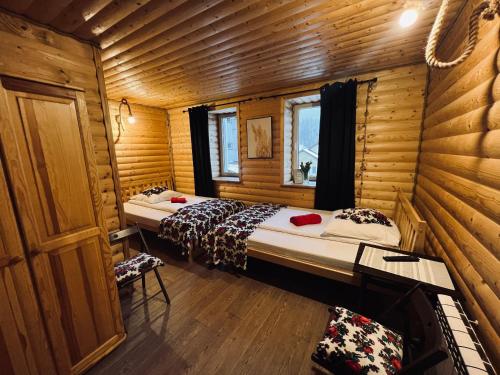sypialnia z 2 łóżkami w drewnianym domku w obiekcie Noclegi Przystanek Bieszczady w Centrum w mieście Ustrzyki Dolne
