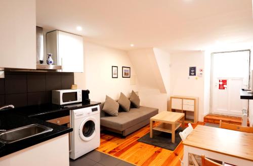 a kitchen and a living room with a couch at Apartments Center Castelo in Lisbon