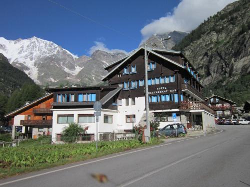 a building on the side of a road with a mountain at Hotel Nuovo Pecetto in Macugnaga