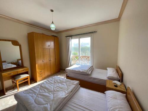 een slaapkamer met 2 bedden, een spiegel en een raam bij Sunny lakes resort in Sharm El Sheikh
