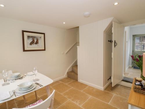 a dining room with a white table and chairs at Old Farm Cottage in Upper Sapey