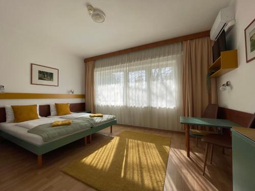 a bedroom with a bed in front of a window at Hello Balcsi Apartmanház in Tihany