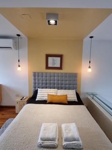 1 dormitorio con 1 cama con 2 toallas en STUDIO 8CERRO 4Pax en la mejor zona de Córdoba Arg en Córdoba