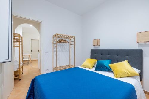 Un dormitorio con una cama azul con almohadas amarillas y azules en Elle Cavour Apartment en Roma