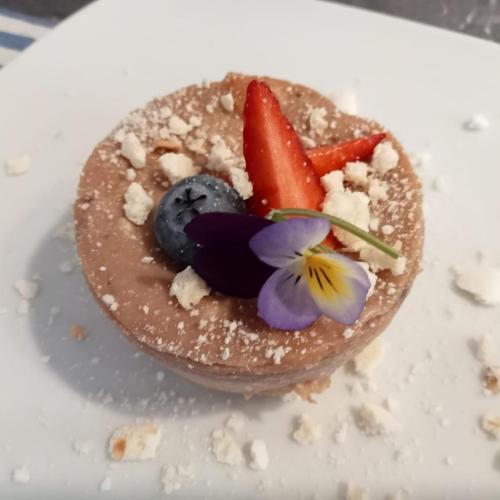 a dessert with fruit and a flower on a plate at SANTINO'S HOUSE in Peveragno