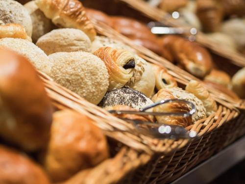 a bunch of baskets filled with different types of bread at Hotel Navarra Brugge in Bruges
