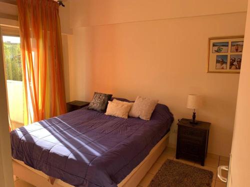 a bedroom with a bed with purple sheets and a window at Bel appartement au cœur de Hay Ryad in Rabat
