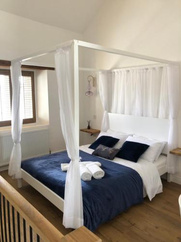 a bedroom with a canopy bed with towels on it at Honeybee Cottage, Waddington in Waddington