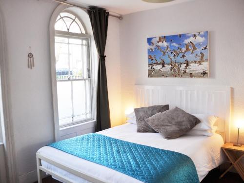 a bedroom with a white bed and a window at Motel Schmotel in Brighton & Hove