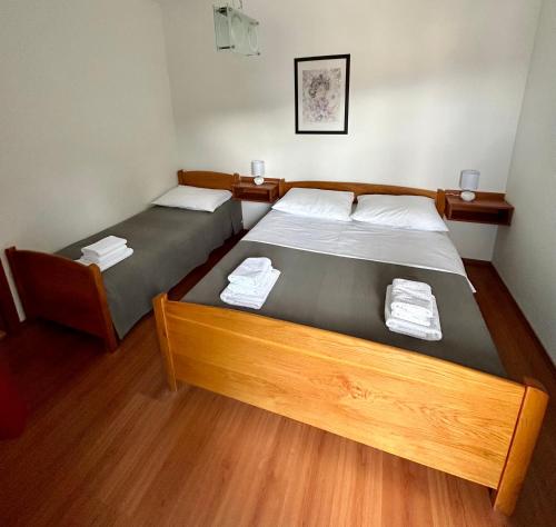 two twin beds in a room with wooden floors at Apartments Štokić in Rab