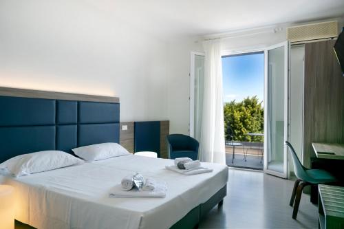 una camera con un grande letto e un balcone di Hotel Riviera a Desenzano del Garda