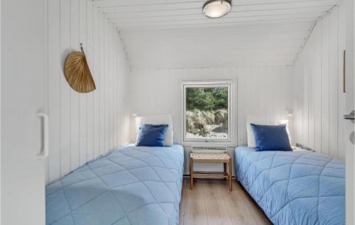 ブラーバンドにあるStunning Home In Blvand With 4 Bedrooms, Sauna And Indoor Swimming Poolの白い部屋のベッド2台 青い枕付