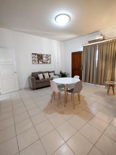 聖胡安的住宿－Departamento Urquiza，客厅配有桌椅和沙发