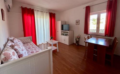 sala de estar con cortinas rojas y sofá en Apartments Štokić, en Rab