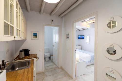 una cocina con fregadero y una cama en una habitación en Mykonos Psarou Place en Psarou
