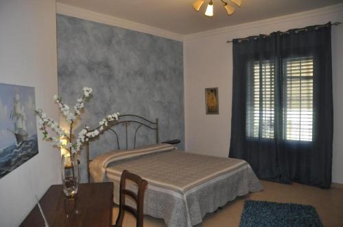 a bedroom with a bed and a table and a window at Granello di Sabbia in San Vito lo Capo