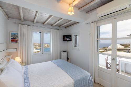 a bedroom with a bed with a view of the ocean at Mykonos Psarou Place in Psarou