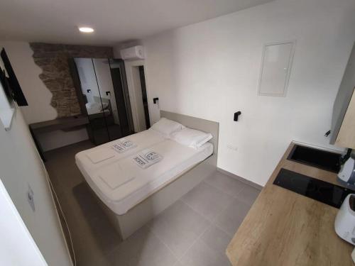 a small bedroom with a bed and a mirror at The center of Split, renovated stone house in Split