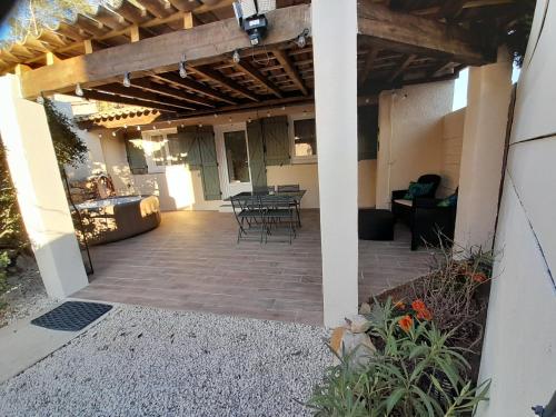 un patio avec une table et des chaises dans un bâtiment dans l'établissement les arbousiers brignoles piscine et spa, à Brignoles