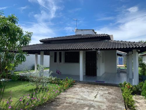 una pequeña casa blanca con techo en Casa com piscina em Barra de Jacuípe BA, en Barra do Jacuípe