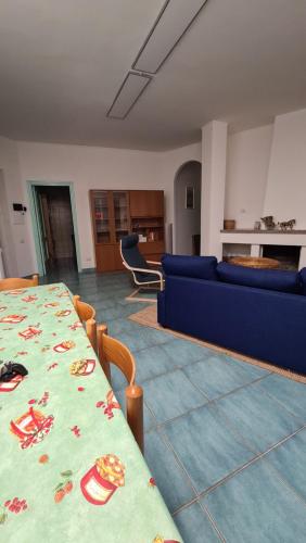 sala de estar con mesa y sofá azul en Villa Palinuro, en Palinuro