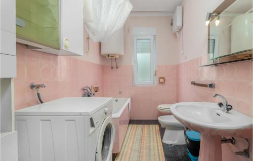 a pink bathroom with a washing machine and a sink at Beautiful Apartment In Crikvenica With 2 Bedrooms And Wifi in Crikvenica