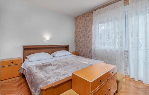 a bedroom with a large bed and a wooden dresser at Beautiful Apartment In Crikvenica With 2 Bedrooms And Wifi in Crikvenica