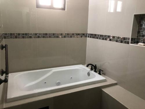 a white bath tub in a bathroom with a sink at Casa Coral in Progreso in Progreso