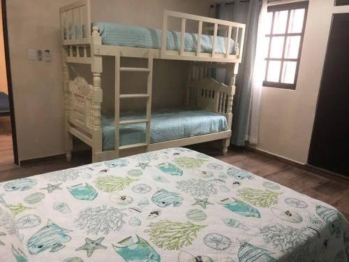 a bedroom with two bunk beds and a bed with a mattress at Casa Coral in Progreso in Progreso